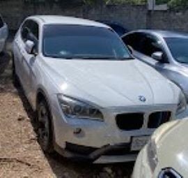 White BMW SUV parked in outdoor lot with other vehicles nearby