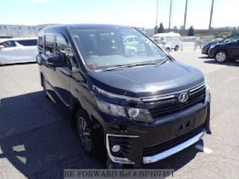 Black Toyota minivan parked in a lot with other vehicles visible in the background